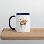 11 oz | Front view of white and blue Yeshua King ceramic coffee mug on a wooden board, featuring ישוע in Hebrew beneath a dripping gold crown with blue handle, rim, and interior.