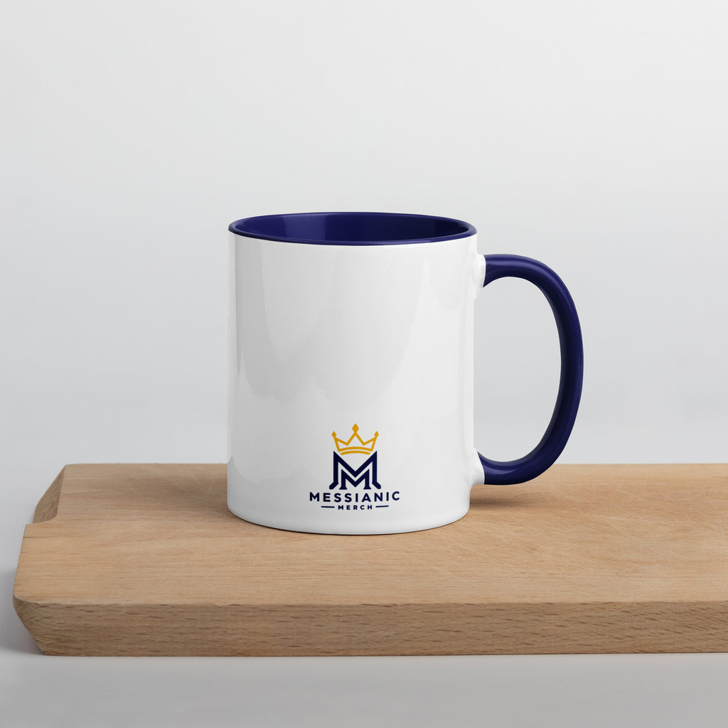 11 oz | Back view of white and blue Yeshua King ceramic coffee mug on a wooden board, featuring Messianic merch logo with blue handle, rim, and interior.